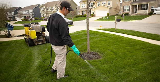 Lawn Pride professional spraying a yard.