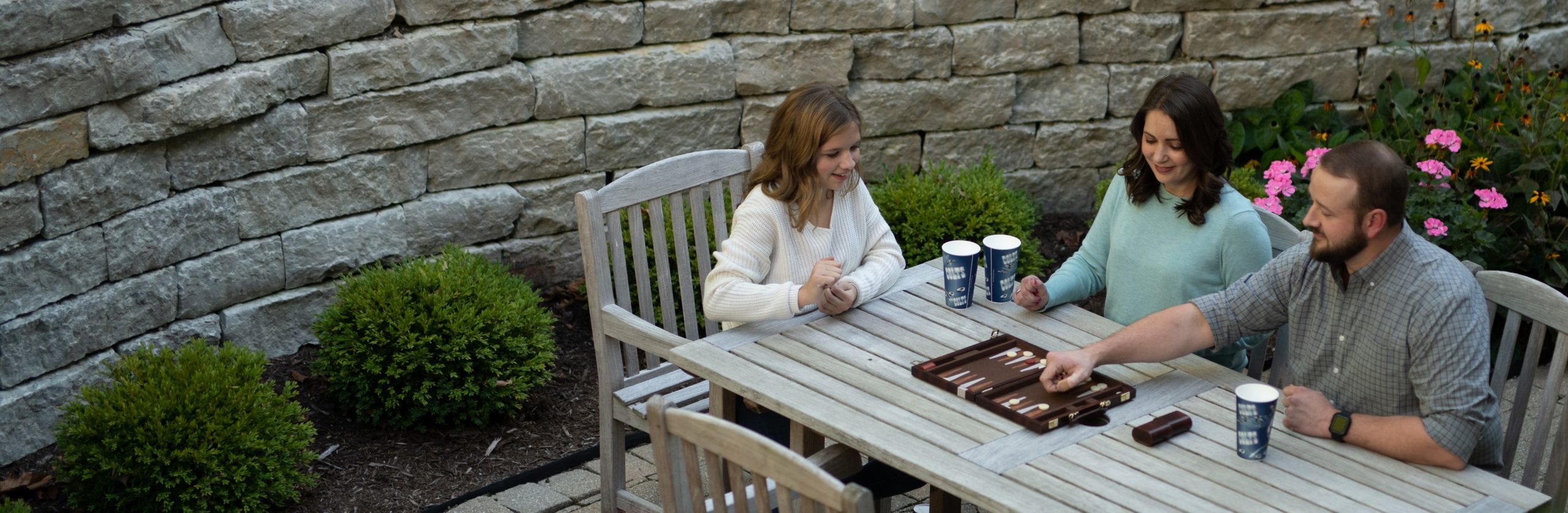 family playing board game in backyard patio