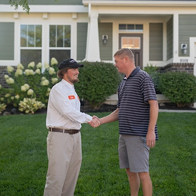Lawn Pride professional shaking hands with customer