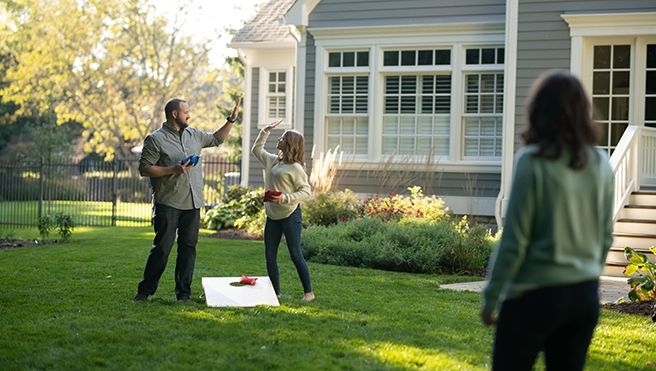 Cornhole game set up in a garden.