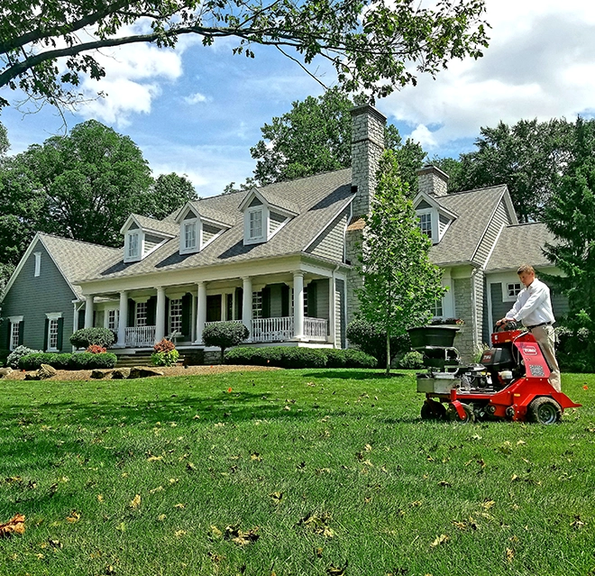 Lawn care worker mowing a yard.