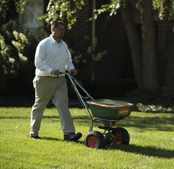 A man using a machine in a grass field.
