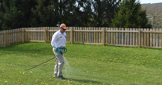 A Lawn Pride employee watering a customer's yard.