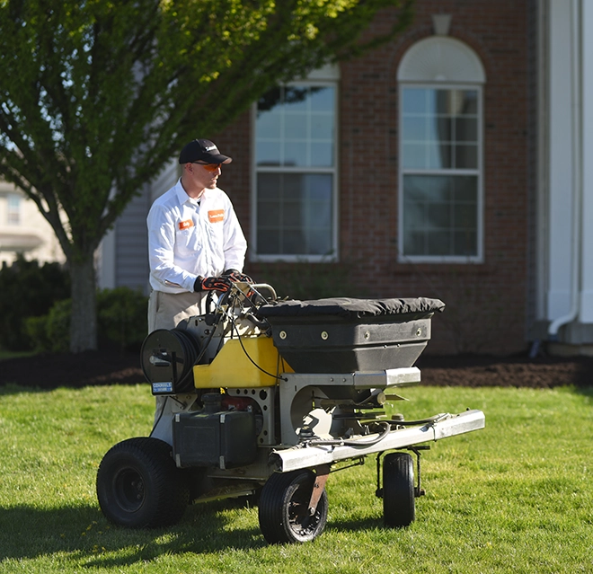 Man working in a grass field with a machine.