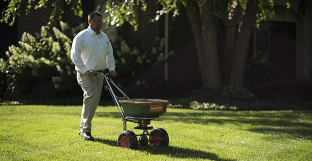 A Lawn Pride professional fertilizing lawn.