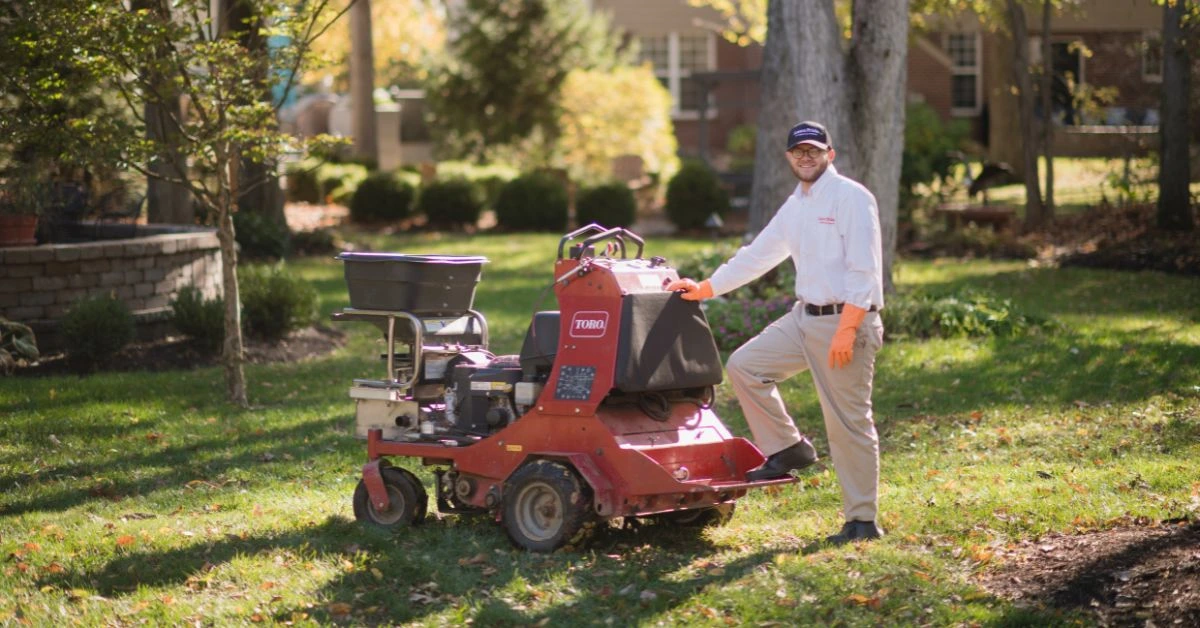Lawn Pride associate standing next to mower