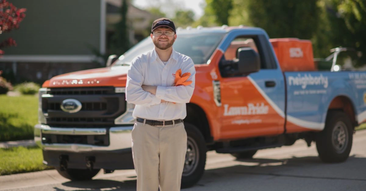 Lawn Pride associate standing in front of Lawn Pride vehicle